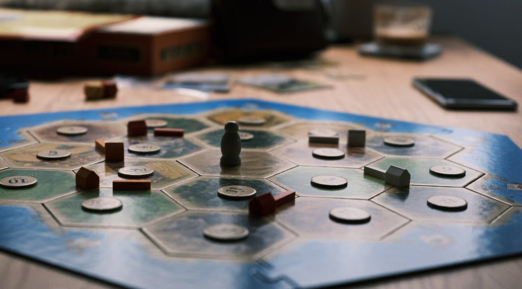 settlers of catan being played on a board game table